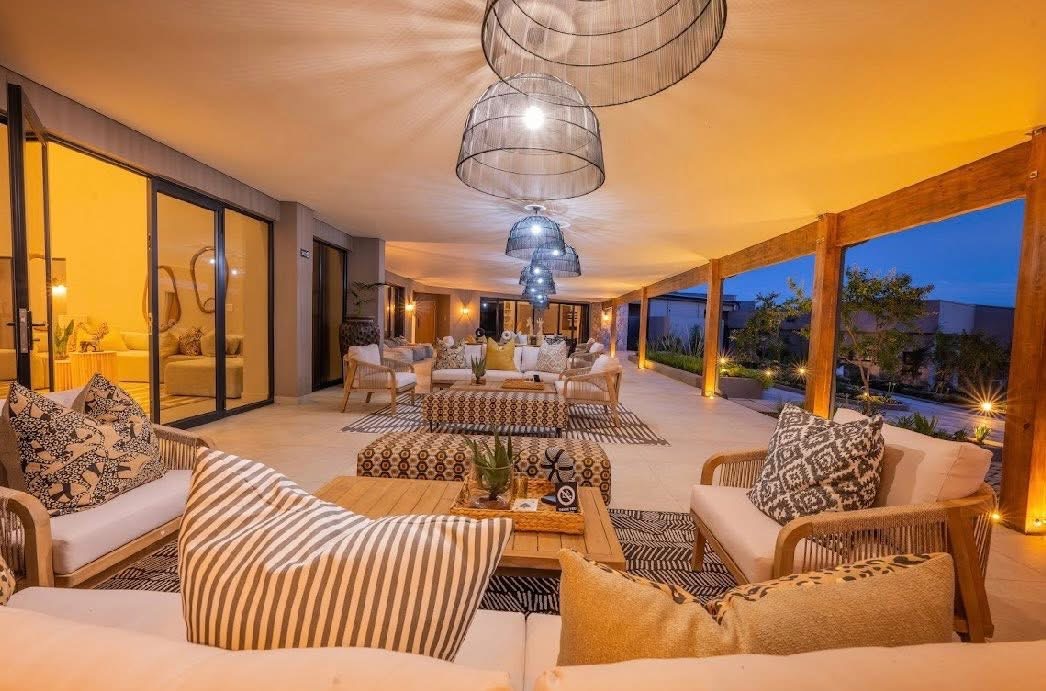 Covered veranda lounge at White River Manor at dusk with upholstered seating, rugs and timber posts