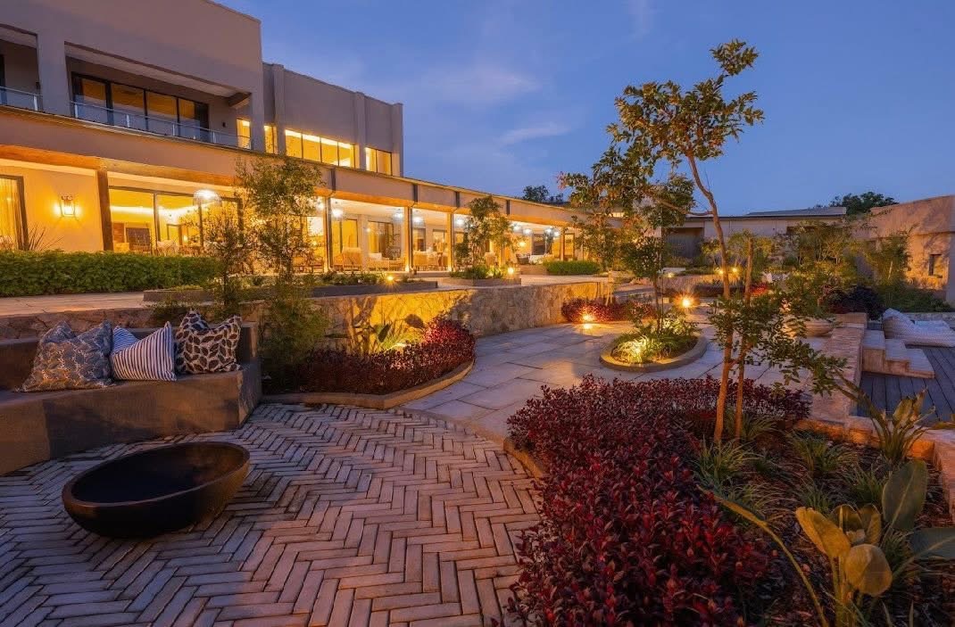Landscaped courtyard at White River Manor at dusk with a sunken fire-pit seating area and stone retaining walls