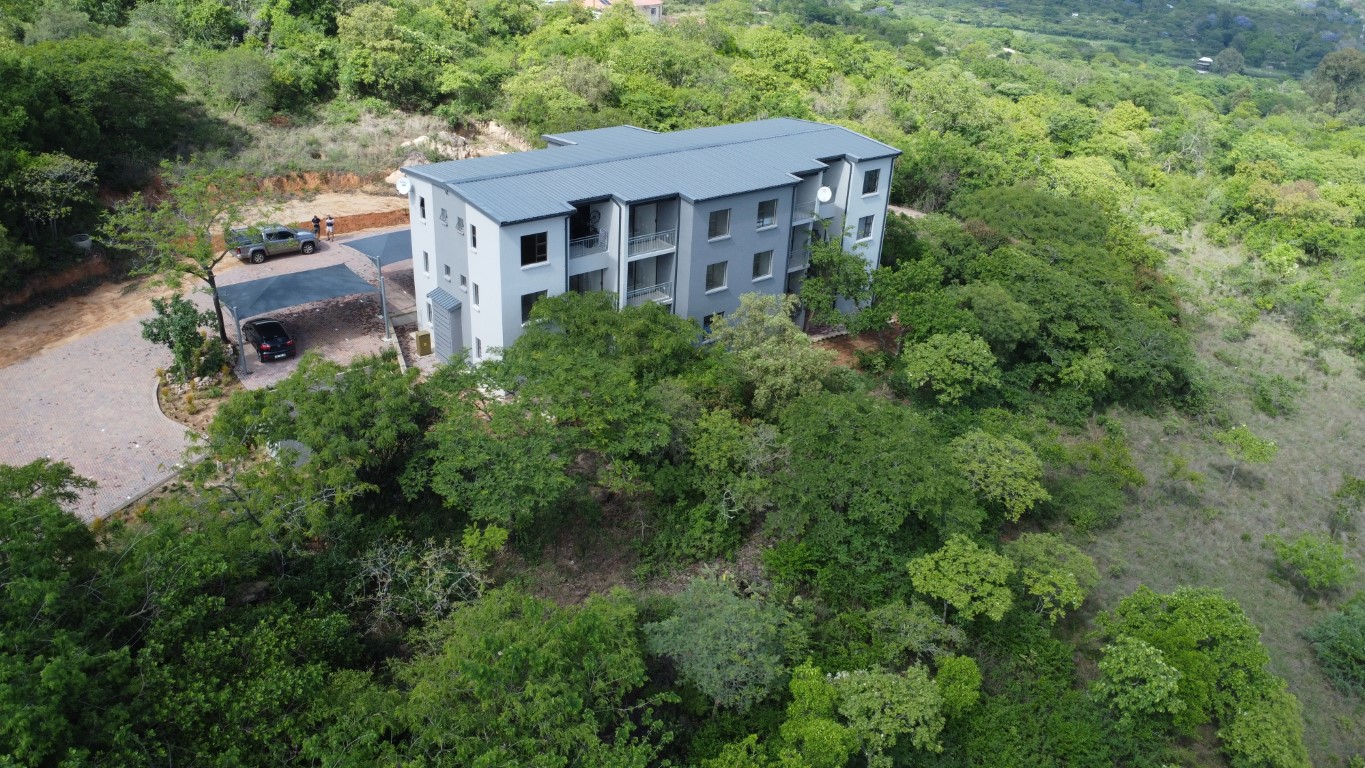Aerial view of a completed apartment block surrounded by bushveld